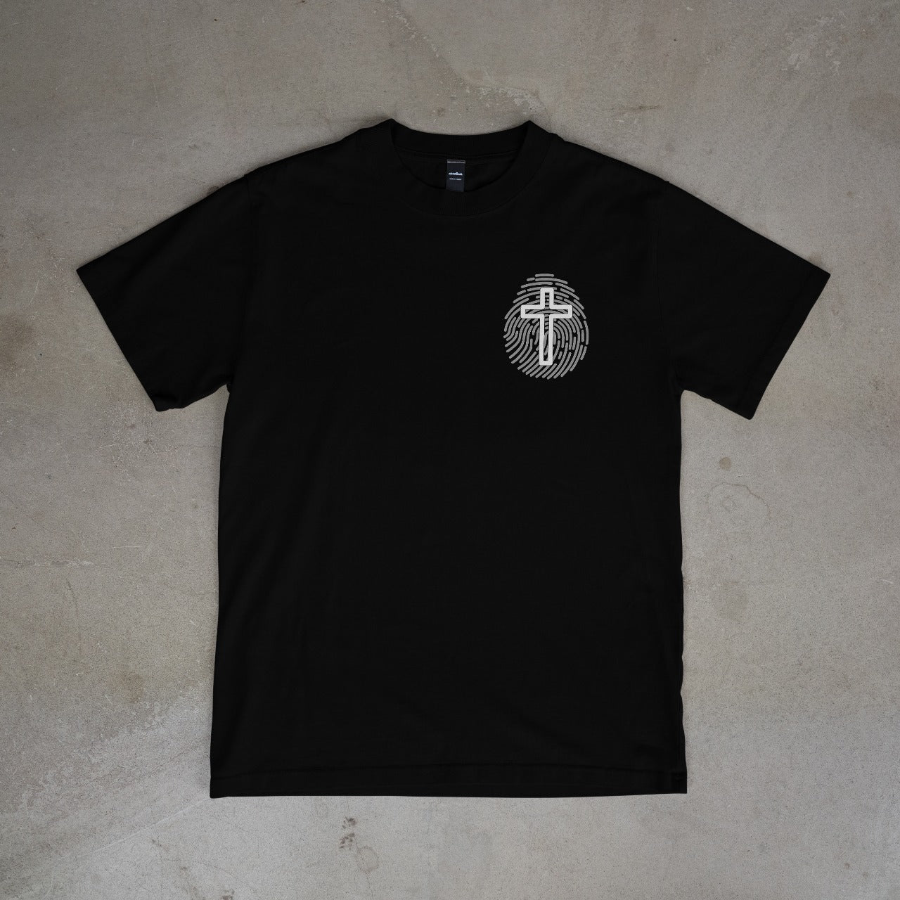 Black t-shirt with a white logo on a gray surface